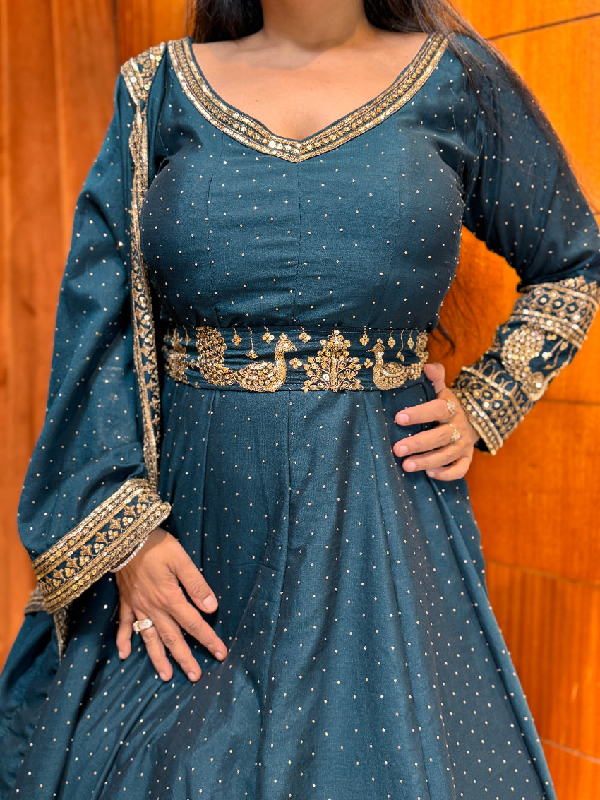 Blue dress with gold embroidery against a wooden background