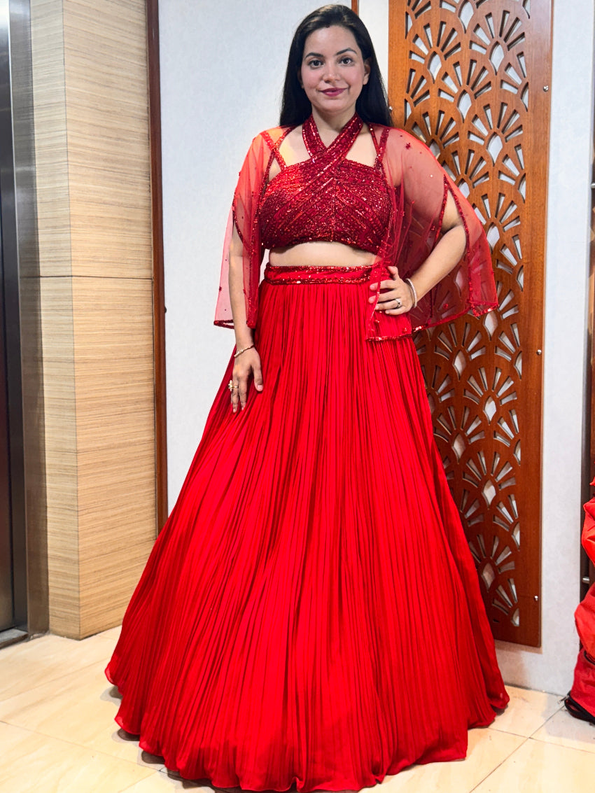 Red Sequin Halter Neck Blouse with Pleated Lehenga Skirt and Sheer Cape
