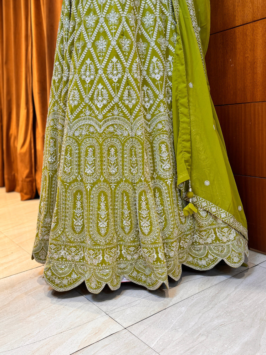 Green embroidered traditional outfit on a wooden floor