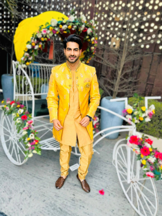 Dazzle in our Mango Yellow Front Open Asymmetrical Achkan with Golden Kurta Pant, the epitome of modern elegance for sangeet, haldi, cocktail, reception, and wedding festivities. Radiating vibrancy with its mango yellow hue, this ensemble boasts intricate asymmetrical design for a contemporary edge. Paired with golden kurta pants, it exudes regal charm and sophistication. Step into the limelight with confidence, making a bold statement on your special day.