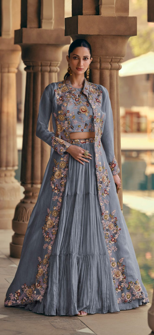 Woman in a traditional outfit with floral embroidery standing in an architectural setting.