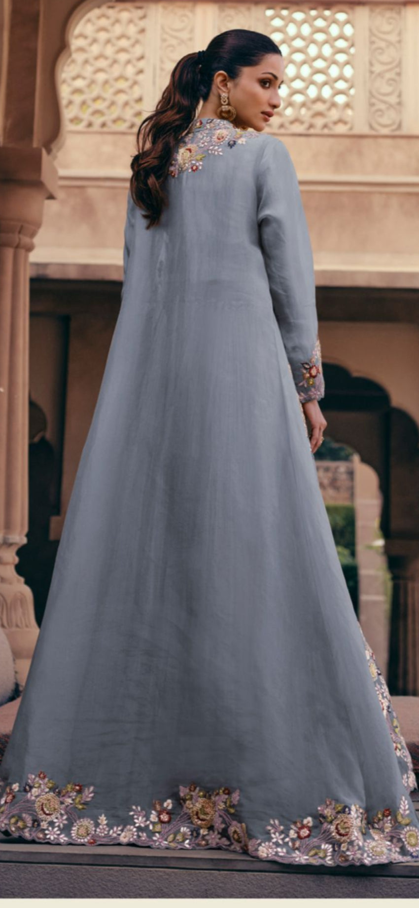 Woman wearing a gray embroidered dress in an outdoor setting