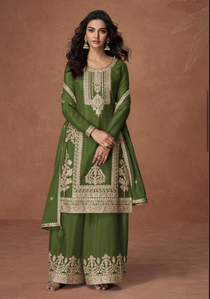 Woman wearing a green embroidered traditional outfit on a brown background