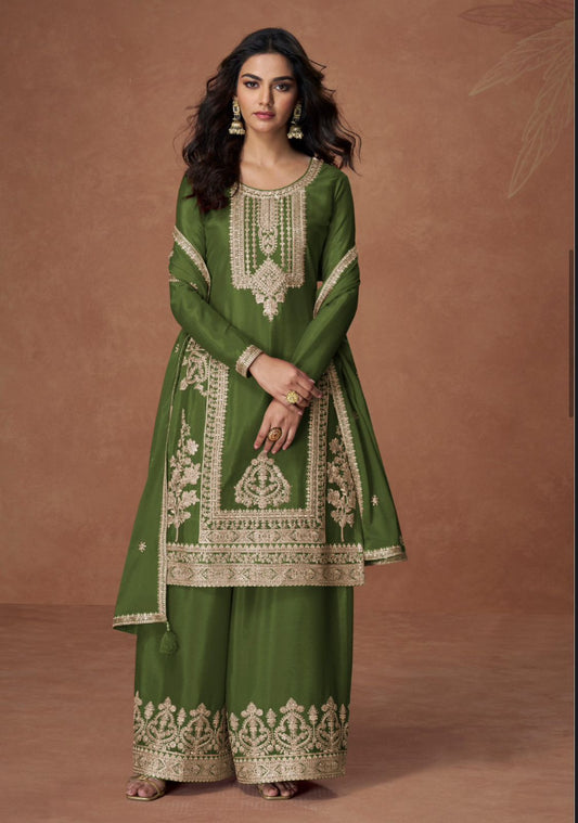 Woman wearing a green embroidered traditional outfit on a brown background